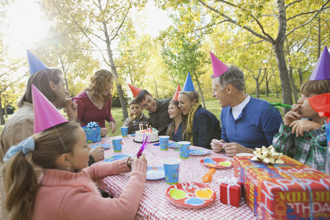 Multi-generation family celebrating girls birthday in park